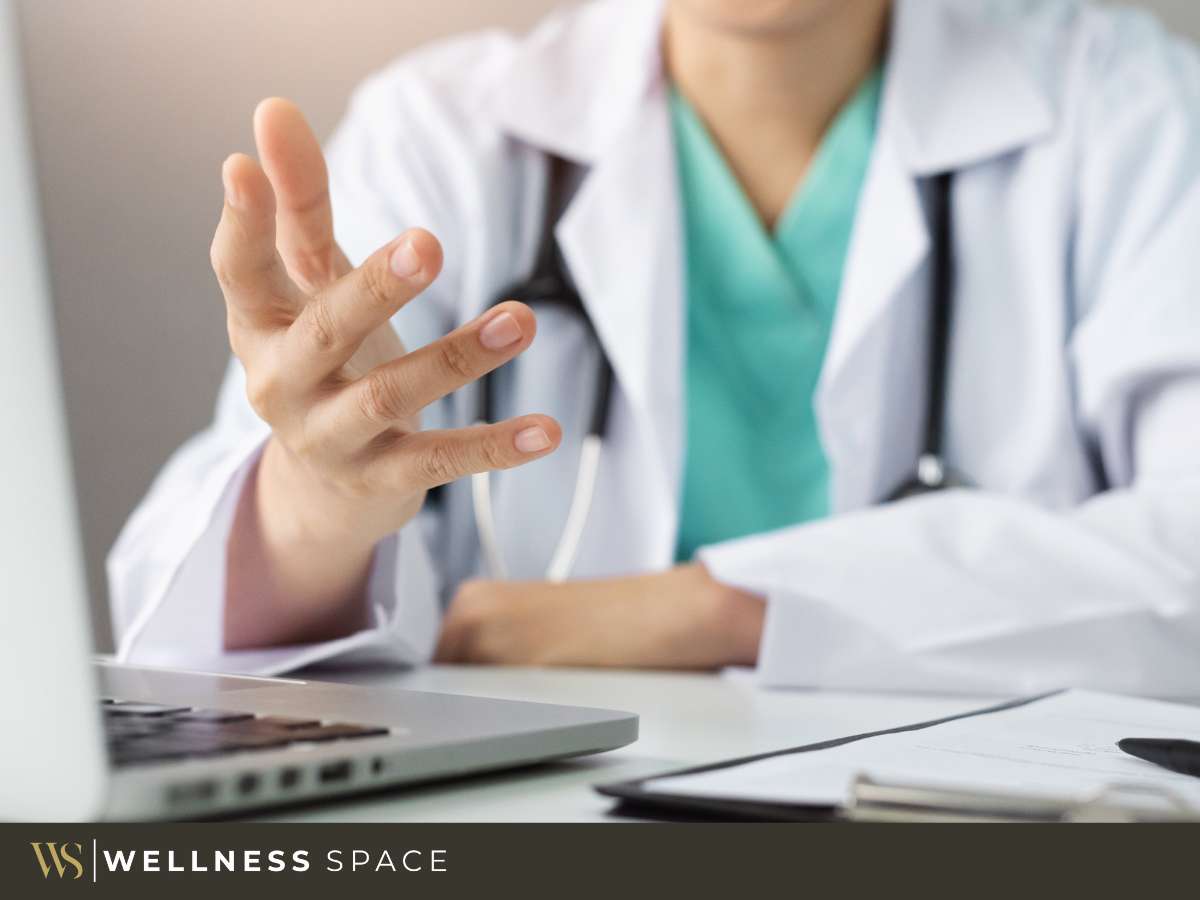 A doctor in a private medical practice interacting with a virtual interface at a laptop